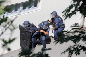 Derrière leur lourd bouclier en kevlar, un policier formé au maniement du fusil G36 se tient prêt à riposter.